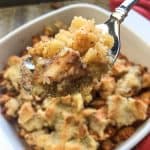 Forkful of Baked Cinnamon Apples in a white casserole dish