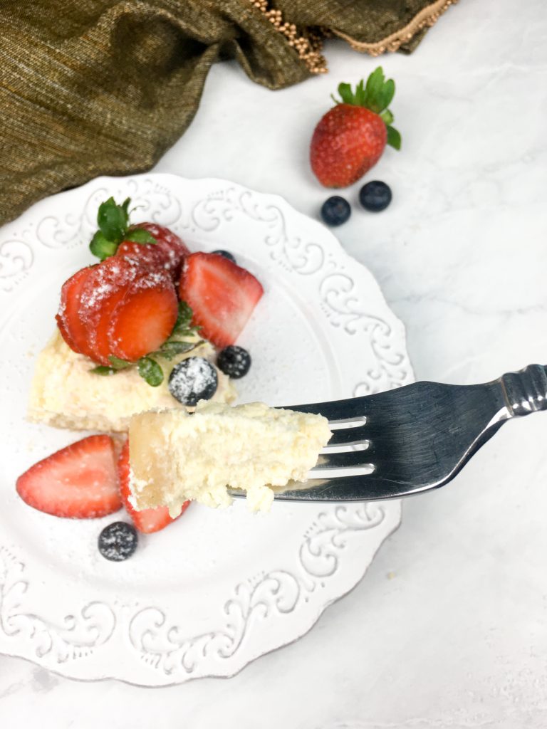 bite of instant pot Cheesecake with strawberries and blueberries