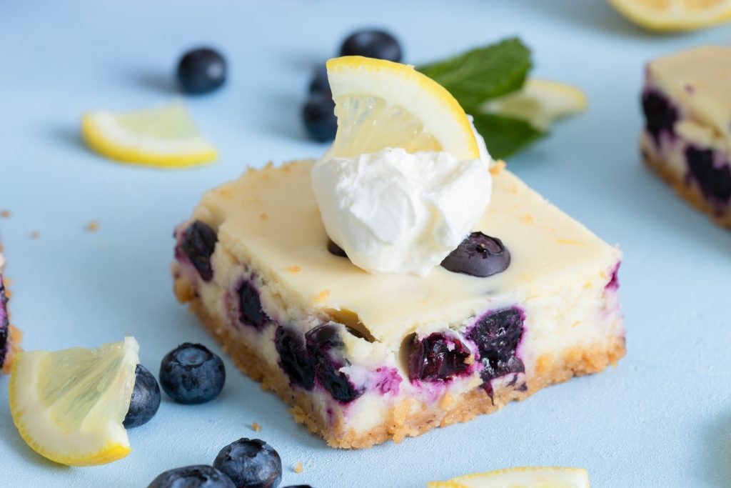 lemon blueberry cheesecake bars with lemon and whipped cream