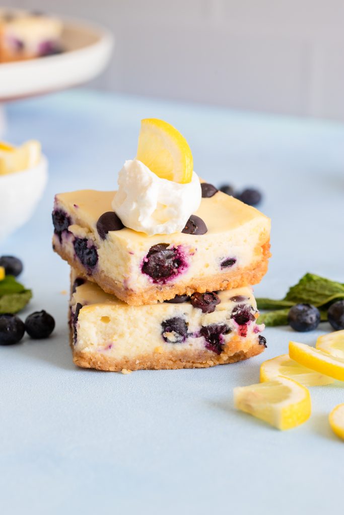 lemon blueberry cheesecake bars with lemon and whipped cream
