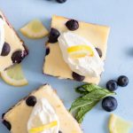 2 Lemon Blueberry Cheesecake Bars garnished with mint and blueberries