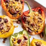 Close-up of taco-stuffed peppers with melted cheese and visible red beans and corn.