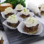 Meatloaf muffins in paper liners with mashed potato topping and parsley.