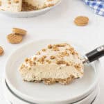 A slice of peanut butter pie on a white plate with a layered cookie crust.