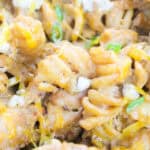 Close-up of buffalo chicken pasta with blue cheese and green onions.