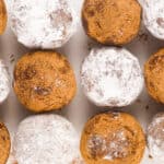 Rows of round chocolate truffles, some coated in powdered sugar and others in cocoa powder, arranged neatly on a white surface—these no bake Christmas treats are perfect for festive gatherings.