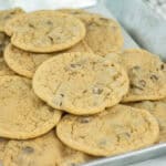 A metal tray filled with a pile of golden brown chocolate chip cookies, showing their soft texture and visible chocolate chips—an inventive use for pancake mix in baking delicious treats.