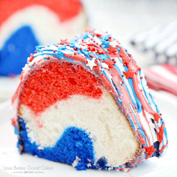 A close-up of a red, white, and blue bundt cake slice, topped with drizzled icing, sprinkles, and star-shaped decorations—perfect for Red White & Blue Cake Decorating Ideas and festive Fourth of July celebrations.