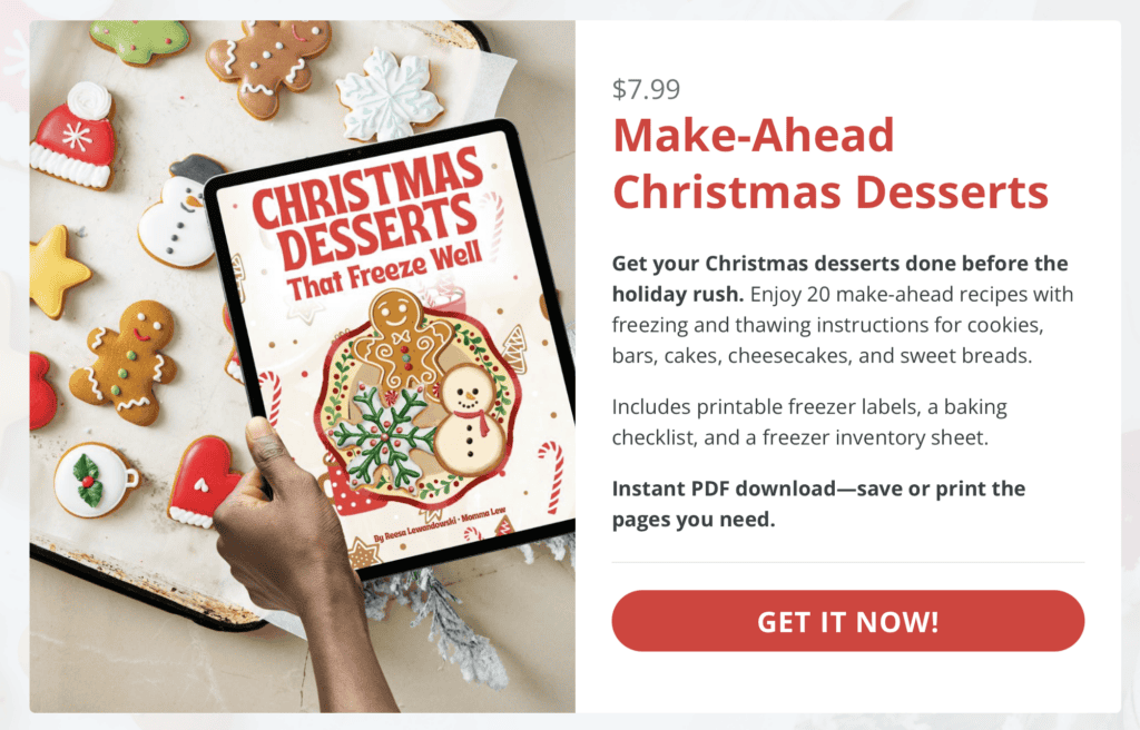 A person holds a tablet displaying a Christmas Dessert Shots ebook cover titled Christmas Desserts That Freeze Well, surrounded by festive cookies on a baking sheet, with product details and a Get It Now! button to the right.
