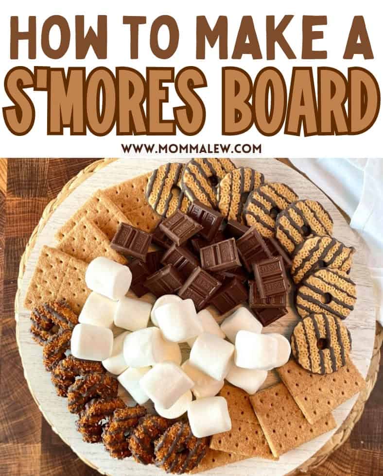 A round wooden s'mores charcuterie board topped with graham crackers, chocolate bars, marshmallows, and chocolate-covered cookies, all arranged for making s’mores. Text above reads, How to Make a Smores Board.