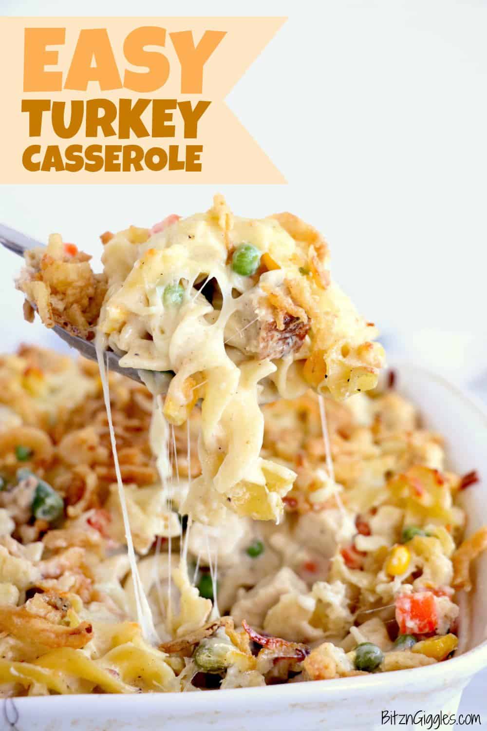 A spoon lifts a cheesy serving of turkey casserole with noodles, peas, corn, carrots, and a crispy topping. Text reads Easy Turkey Casserole. The dish is in a white baking pan.