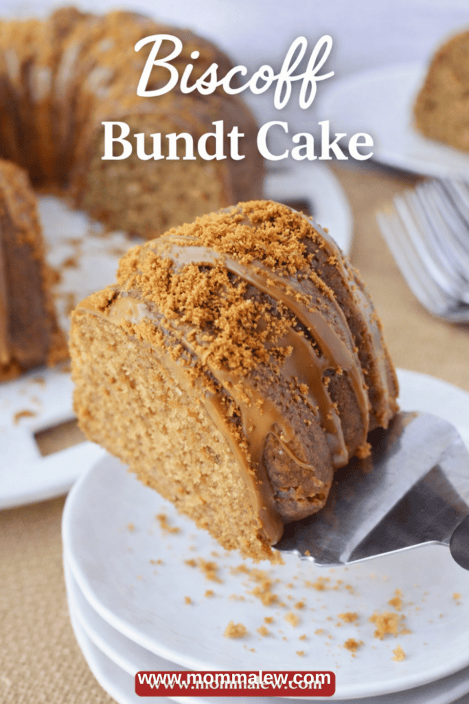 A close-up of a Biscoff Bundt cake slice on a white plate, topped with cookie crumbs and drizzle, with the rest of the Biscoff Bundt cake and some forks in the background. Text reads Biscoff Bundt Cake.