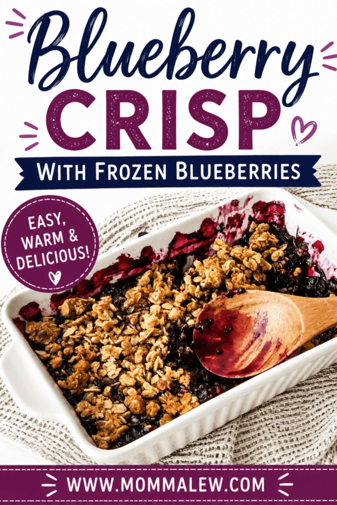 A white baking dish filled with Blueberry Crisp with Frozen Blueberries, a wooden spoon resting inside, sits on a woven placemat. Text reads: Easy, Warm & Delicious Blueberry Crisp with Frozen Blueberries! www.mommalew.com.