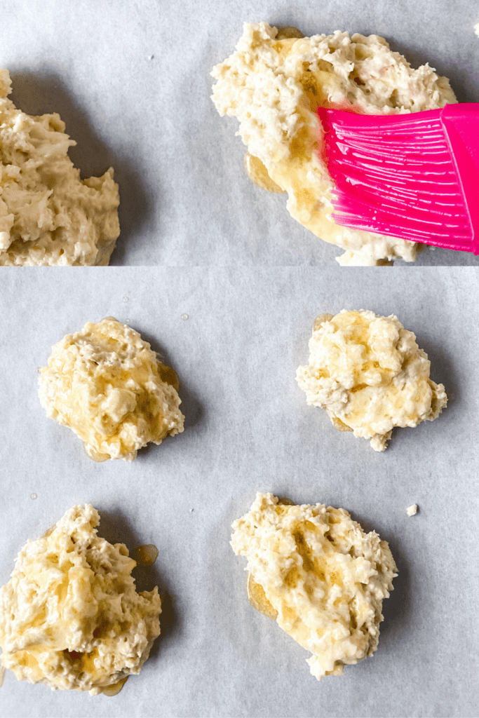 Four unbaked Honey Butter Biscuits dough mounds rest on parchment paper; one is being brushed with melted butter using a pink brush. The image is divided into close-up and wider views, capturing the delicious process.