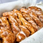 Close-up of freshly baked Apple Cinnamon Pull Apart Bread with a sugar glaze on top, arranged in a parchment-lined pan.